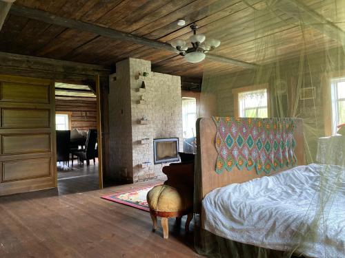 1 dormitorio con cama, silla y piano en Ethnographic holiday house LAIPAS en Murjāņi