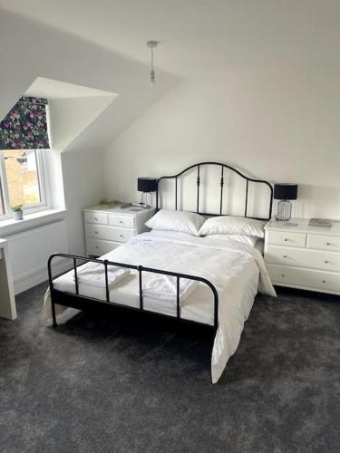Un dormitorio blanco con una cama grande y una ventana. en Ile, en Aldershot