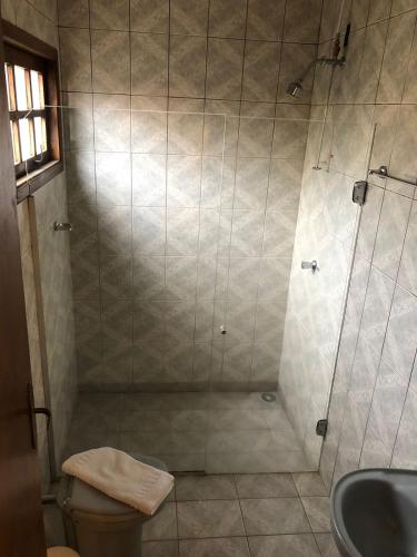 a bathroom with a shower with a toilet and a sink at Pousada Santo Antônio do Pinhal in Santo Antônio do Pinhal