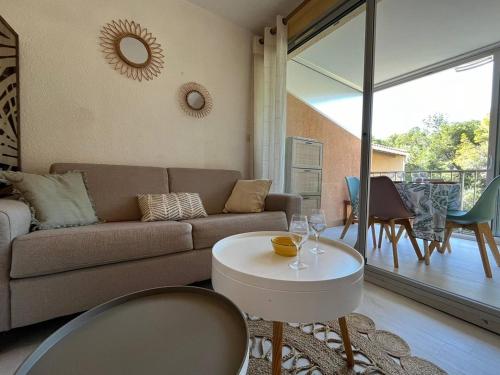 un salon avec un canapé et une table dans l'établissement Appartement T2 Cabine à 200m de la plage à Saint Pierre la mer 4OLIV70, à Saint Pierre La Mer