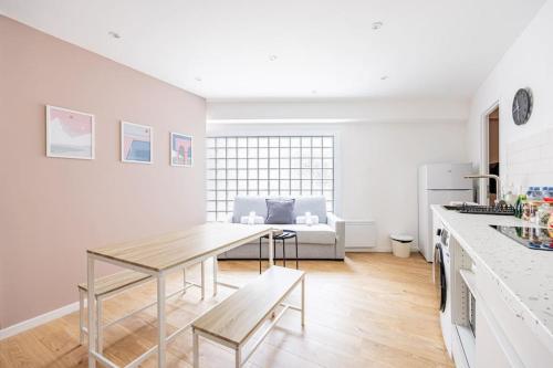 a kitchen and living room with a table and a couch at Charme Parisien 6 Personnes, 2 chambres, 19ème in Paris