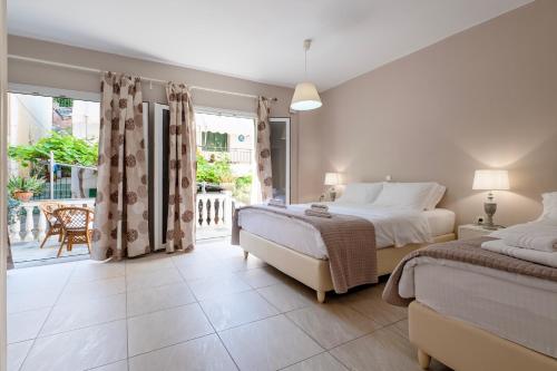 a bedroom with two beds and a large window at Avra in Parga