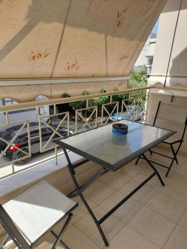 un tavolo e 2 sedie sul balcone di CHRISTINA APARTMENT ΝΕΑ ΠΕΡΑΜΟΣ a Néa Péramos