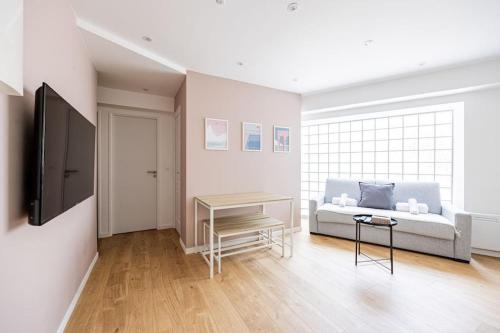 a living room with a couch and a table at Charme Parisien 6 Personnes, 2 chambres, 19ème in Paris