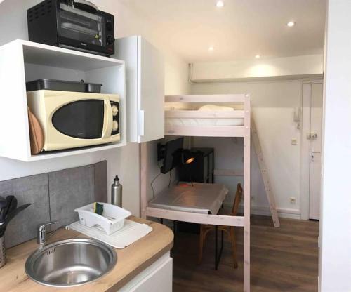 une petite cuisine avec un micro-ondes et un évier dans l'établissement Studio GUITAR, à Chambéry
