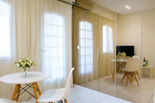 a living room with a table and chairs and a television at Bellevue Suites in Agios Nikolaos