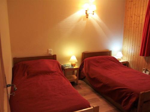 - 2 lits dans une chambre avec des draps rouges dans l'établissement Appartement 3 pièces sud au centre du village, proche remontées, commerces et activités. - FR-1-459-36, à La Clusaz