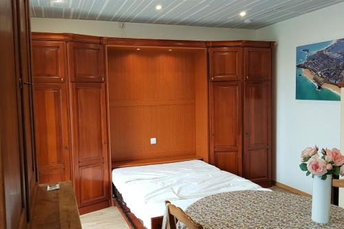 - une chambre avec un lit et des placards en bois dans l'établissement Le Cap Horn, à Dinard