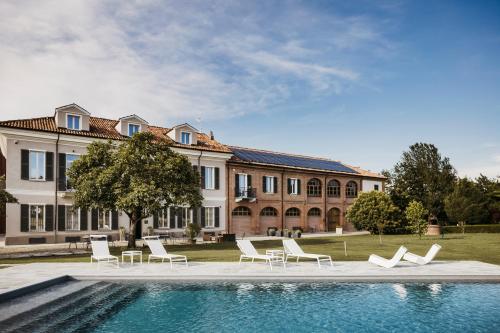 a house with a swimming pool in front of a building at Villa Adelaide Relais & Wine in Calamandrana