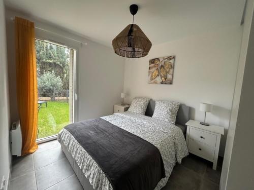 une chambre avec un lit et une grande fenêtre dans l'établissement Jardin Secret C01, à Antibes