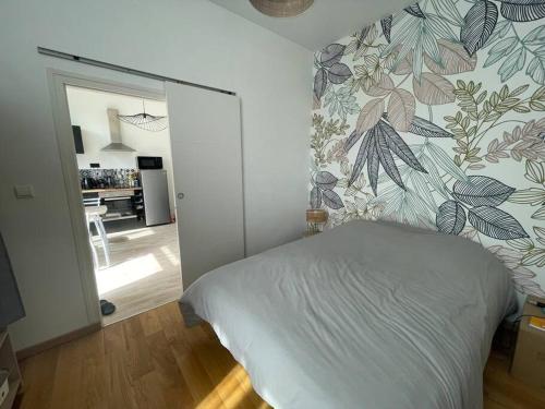 - une chambre avec un lit orné d'un mur fleuri dans l'établissement Maison proche stade de foot, à Auxerre