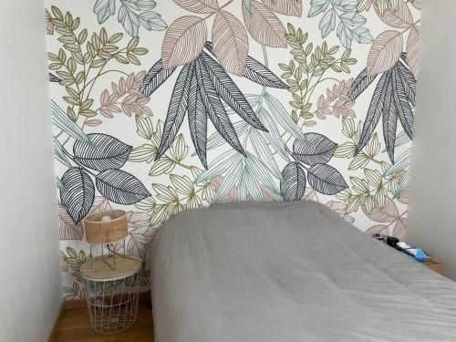 - une chambre avec un mur orné d'un papier peint à fleurs dans l'établissement Maison proche stade de foot, à Auxerre