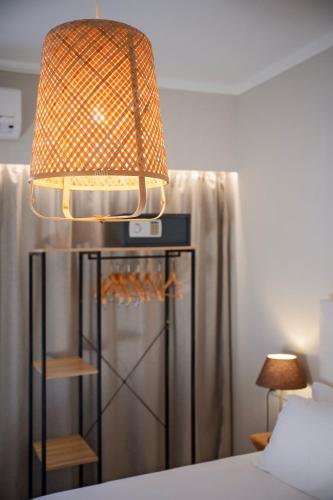 a lamp sitting on top of a bed next to a bed at Avra in Parga