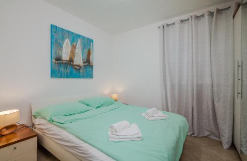 een slaapkamer met een bed met twee handdoeken erop bij Apartment Šop in Čižići