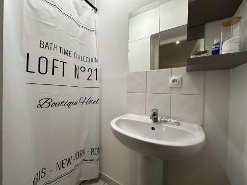 ein weißes Badezimmer mit Waschbecken und Spiegel in der Unterkunft Le Blue- hyper centre ville in Sens