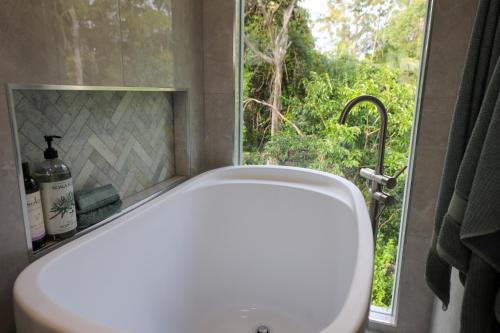 baño con lavabo blanco y ventana en Satin Bower Cottage en Eagle Heights