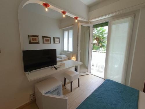 a bedroom with a television and a desk with a tv at Hotel Merano in Grado