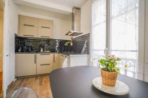 - une cuisine avec une table et une plante en pot dans l'établissement Tranquil retreat in the 16th arrondissement, à Paris