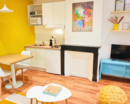 Il comprend une cuisine et une salle à manger avec une table et une cheminée. dans l'établissement CONTEMPORAIN avec Terrasse - Plein centre Ville, à Lisieux