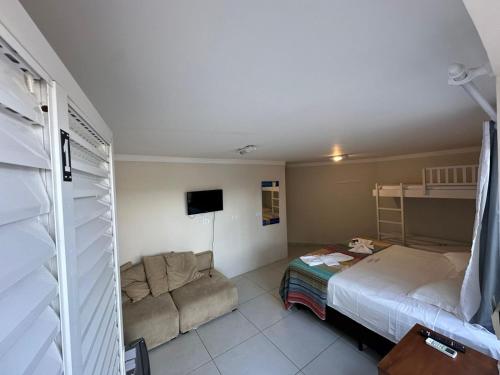 a small room with a bed and a couch at Pousada Mansão Tenório in Ubatuba