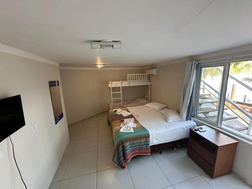 a small bedroom with a bed and a window at Pousada Mansão Tenório in Ubatuba
