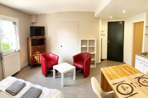 un salon avec des chaises rouges et une table dans l'établissement Studio HOCKEY, à Chambéry