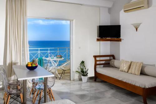 a living room with a couch and a view of the ocean at Bellevue Suites in Agios Nikolaos
