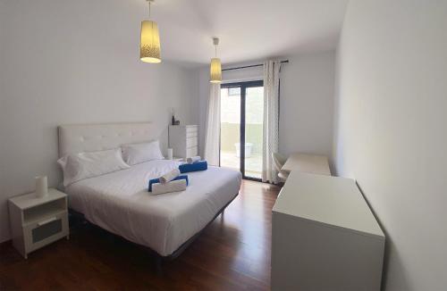a bedroom with a white bed and a window at Harmony - Beach & Dream rentals in Playa de las Americas