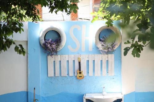 eine blaue Wand mit zwei Spiegeln und einem Waschbecken in der Unterkunft Hostel Osho in Tirana