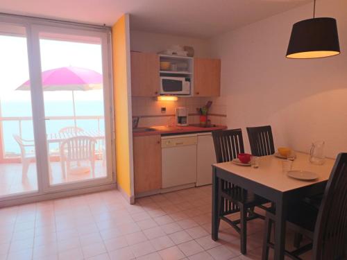 une cuisine et une salle à manger avec une table et un balcon dans l'établissement Studio cabine 4 pers, accès plage, piscine, parking - FR-1-472A-148, à Sète