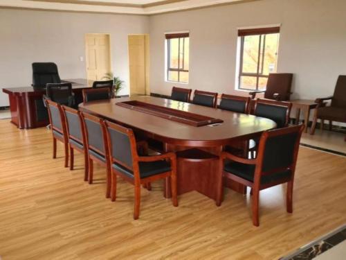 a conference room with a large wooden table and chairs at Lily Park Complex , Self-Catering in Rustenburg