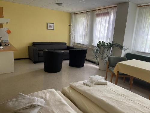 a room with two beds and a couch and a table at Hotel Zum Bären in Kurort Altenberg