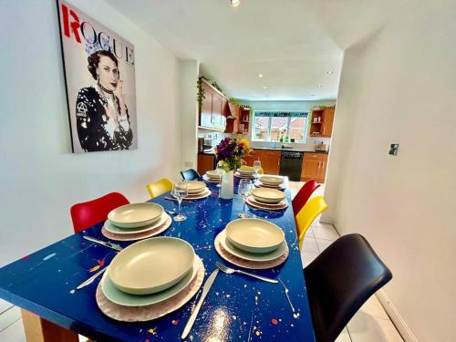 a blue table with chairs and plates on it at 6 Bedroom House - Contractors, Crew, Group, Family in Braintree