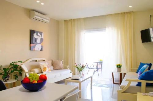 a living room with a couch and a bowl of fruit on a table at Bellevue Suites in Agios Nikolaos