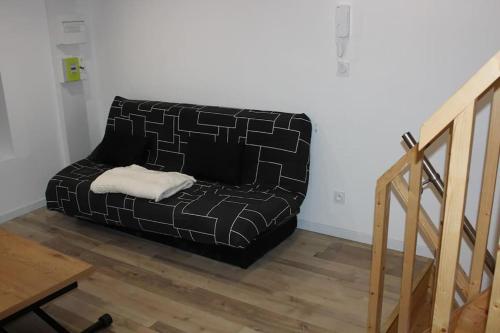 un divano nero seduto nell'angolo di una stanza di Studio avec Mezzanine pour 4 a Royat