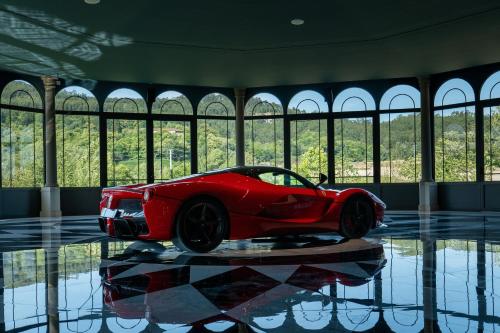 a red car on display in a room with windows at Maison Albar - Amoure in Braga