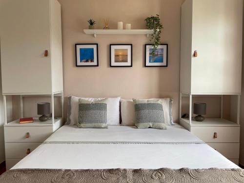 a bedroom with a large white bed with white cabinets at Villa with Private Pool near the Beach and Pula in Sarroch