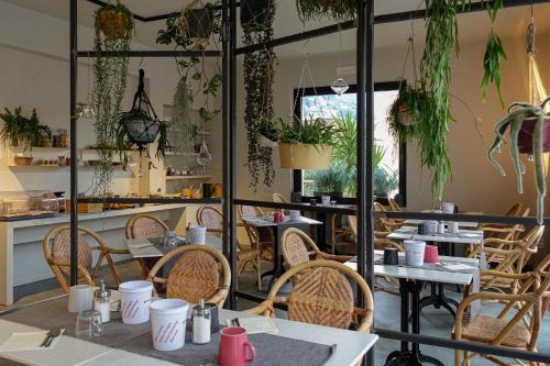 een restaurant met tafels en stoelen en potplanten bij Hotel Peler in Malcesine