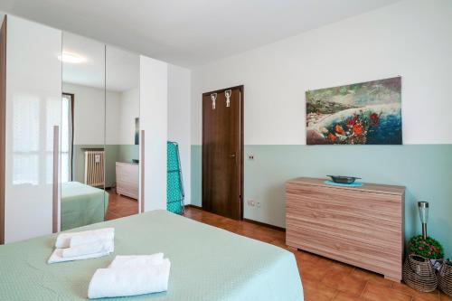 ein Schlafzimmer mit einem Bett und einem Gemälde an der Wand in der Unterkunft Casa Maria - trilocale con patio, garage e WiFi in San Martino della Battaglia