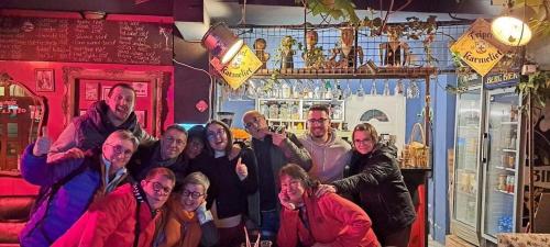 a group of people posing for a picture in a bar at Divina Hostel in Tirana