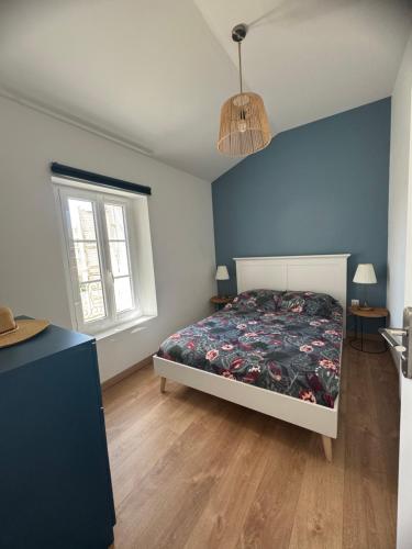 une chambre avec un lit et un mur bleu dans l'établissement Chez Elo : Mourillon - neuf - 1min des plages - Belle Vue Mer, à Toulon