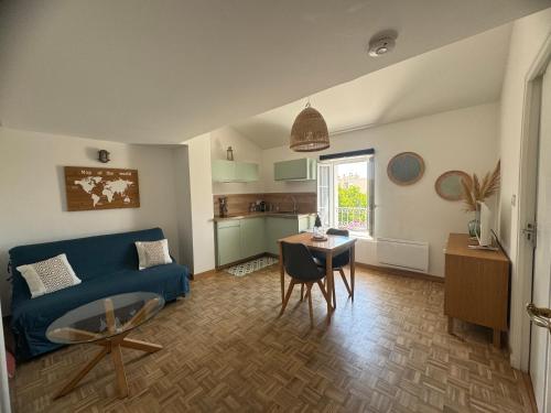 un salon avec un canapé bleu et une table dans l'établissement Chez Elo : Mourillon - neuf - 1min des plages - Belle Vue Mer, à Toulon