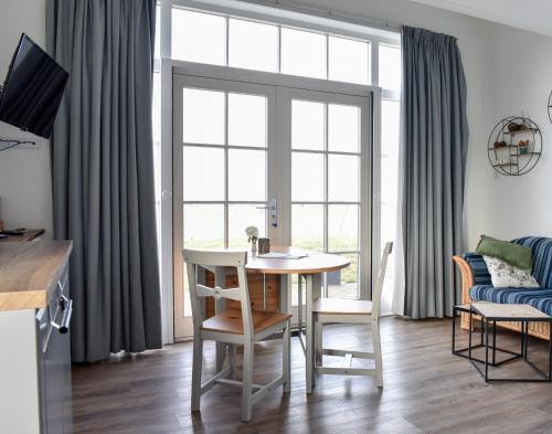 a living room with a table and chairs and a window at Pronkhuisje in Oterleek