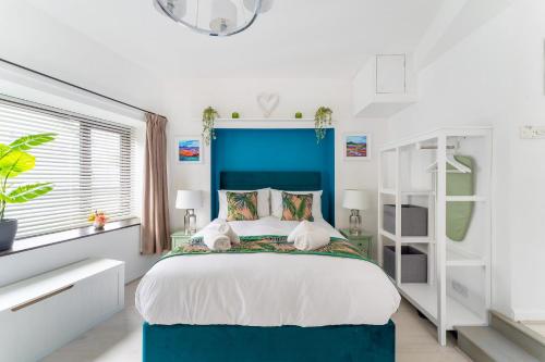 a bedroom with a bed with a blue headboard at 2 The Stables in Bowness-on-Windermere