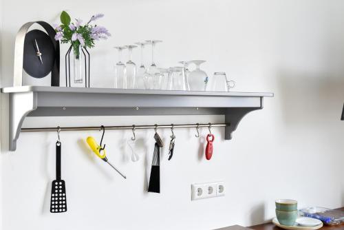 une étagère avec des ustensiles accrochés au mur dans l'établissement Pronkhuisje, à Oterleek