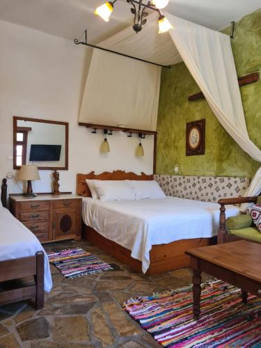 a bedroom with two beds and a table at Spitia Anoi in Palaiochora