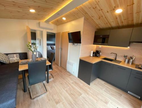 eine Küche und ein Wohnzimmer mit einem Tisch im Zimmer in der Unterkunft Tiny Haus 7 in Nabburg