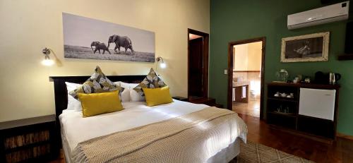 a bedroom with a large bed with yellow pillows at Elephant Hide of Knysna Guest Lodge in Knysna