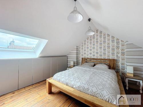 a bedroom with a bed and a skylight at Élégance Malouine - 500m Plage in Dunkerque