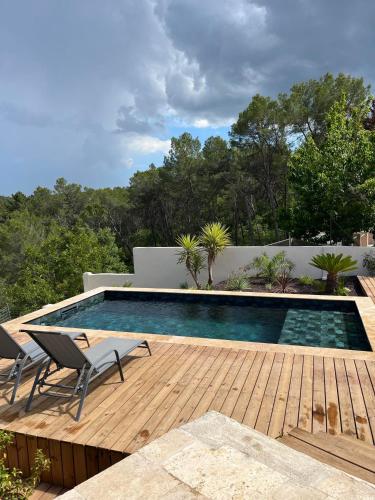 - une piscine avec 2 chaises sur une terrasse en bois dans l'établissement Villa avec piscine privative, à Trans-en-Provence